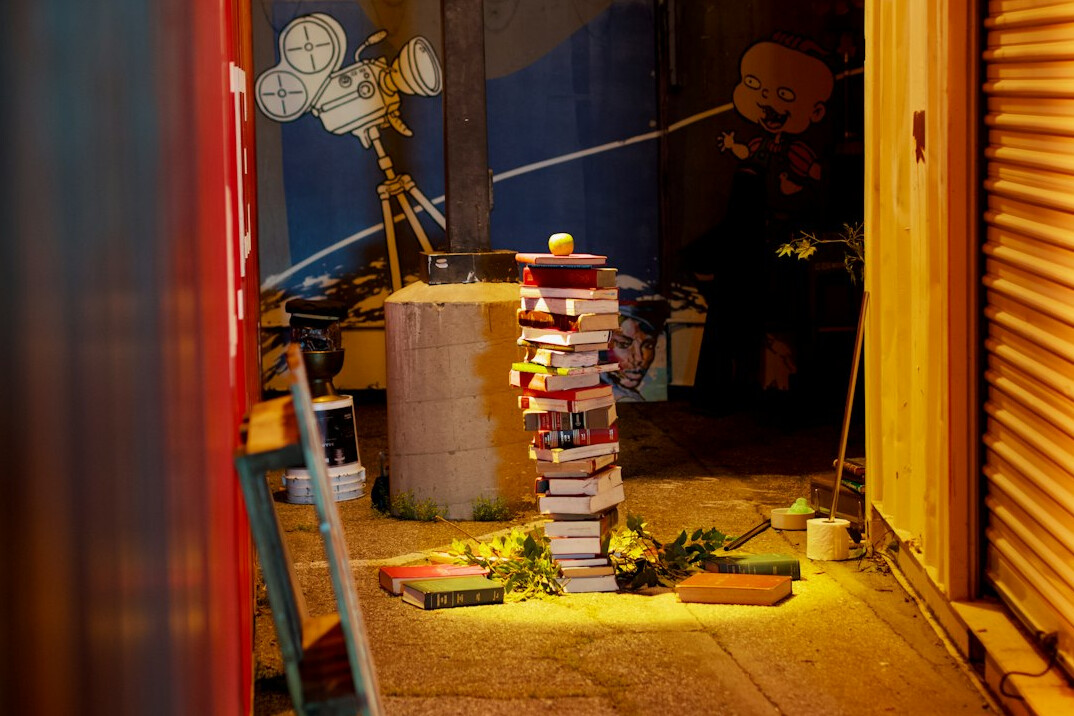 Books arranged in a pile next to a lamp