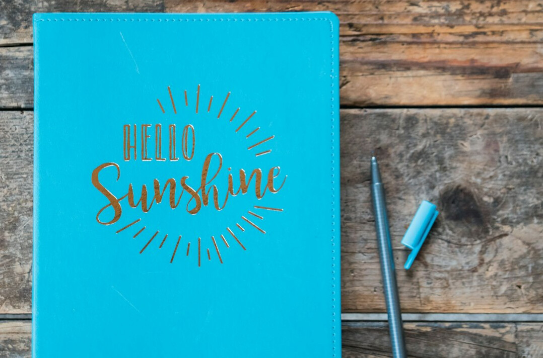 Open detective notebook with pen on a wooden desk